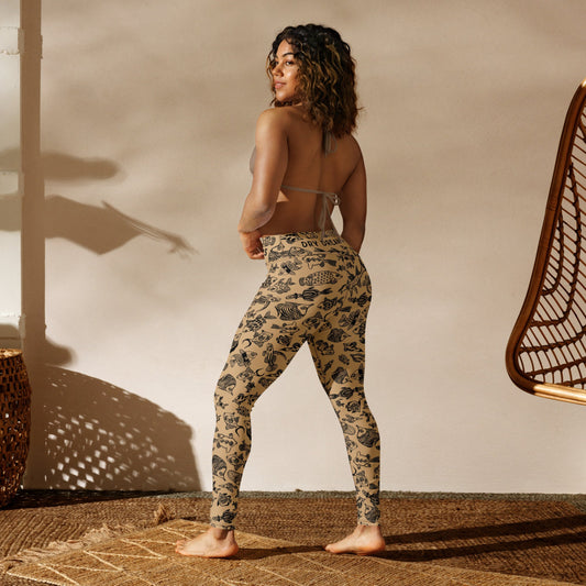 Back view of a woman wearing Plenty of Fish in The Sea recycled leggings with illustrated fish pattern in a studio setting
