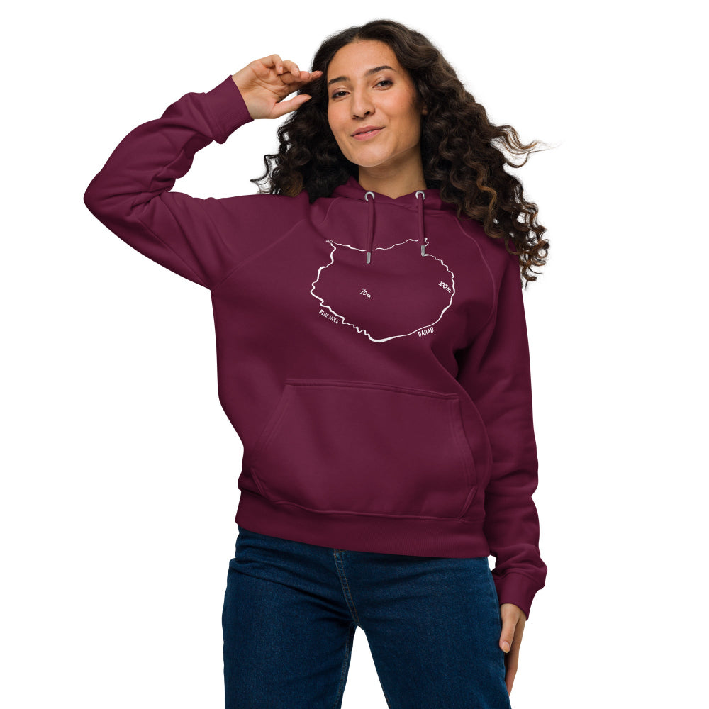 A woman wearing the Blue Hole Eco Hoodie in burgundy, inspired by the Blue Hole in Dahab a famous freediving destination