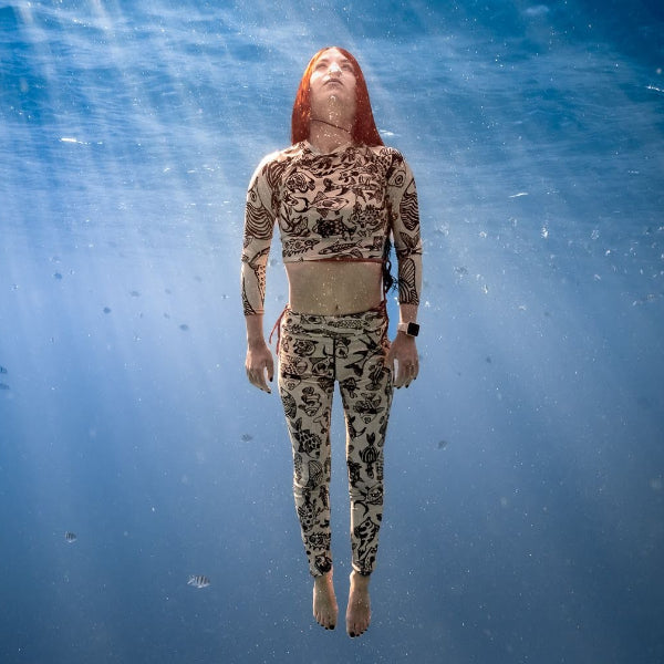 Woman wears yoga set as a rashguard underwater