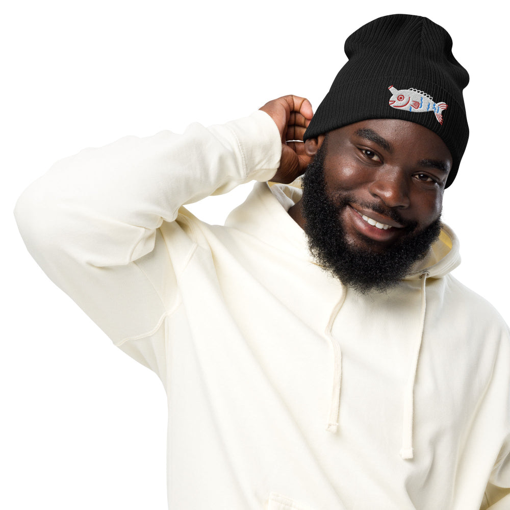 A man wearing a black Fishful Thinking organic ribbed beanie with embroidered unicornfish