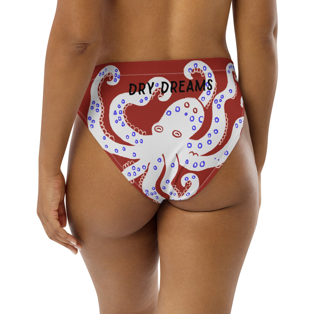 A red recycled bikini bottom swimwear with a pattern of blue fish and sea creatures, back view