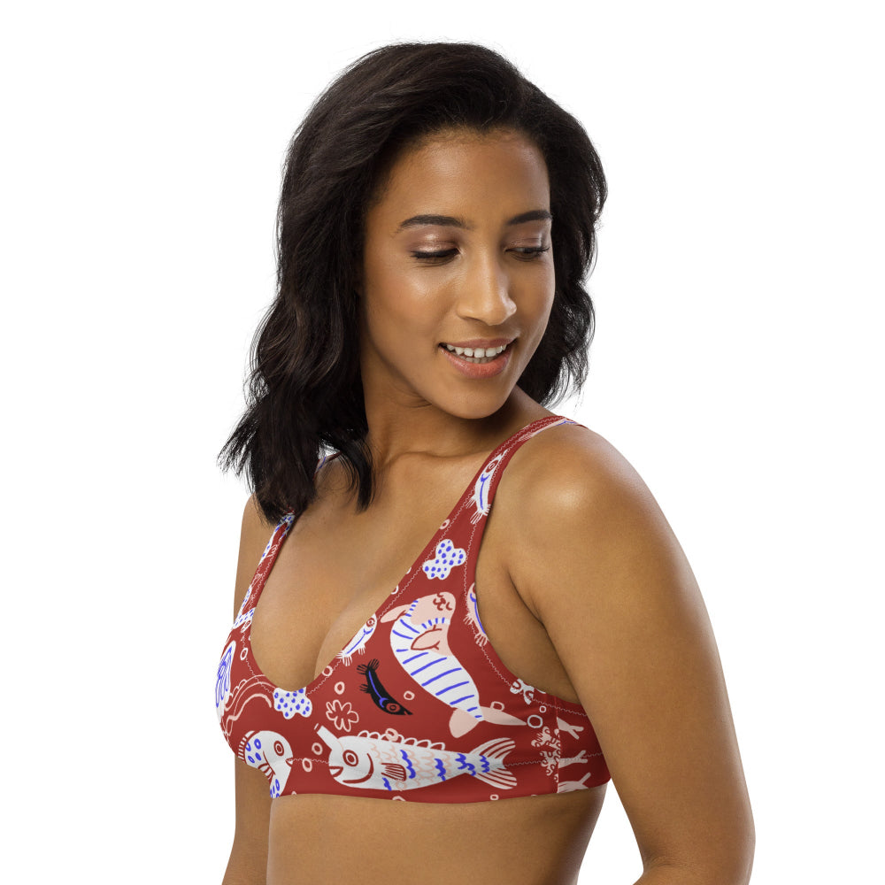 Right front view of a person wearing the Funny Fishes recycled bikini top in red with funny fish design.