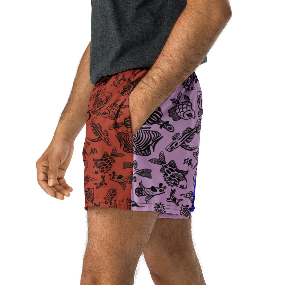 Side view of a person wearing the Harlequin recycled unisex shorts with hand in pocket