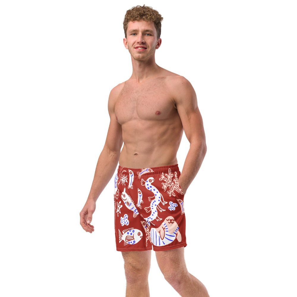 Front angled view of a person wearing Octopuses Dry Dream recycled swimming trunks with fish and sea life lllustrated pattern