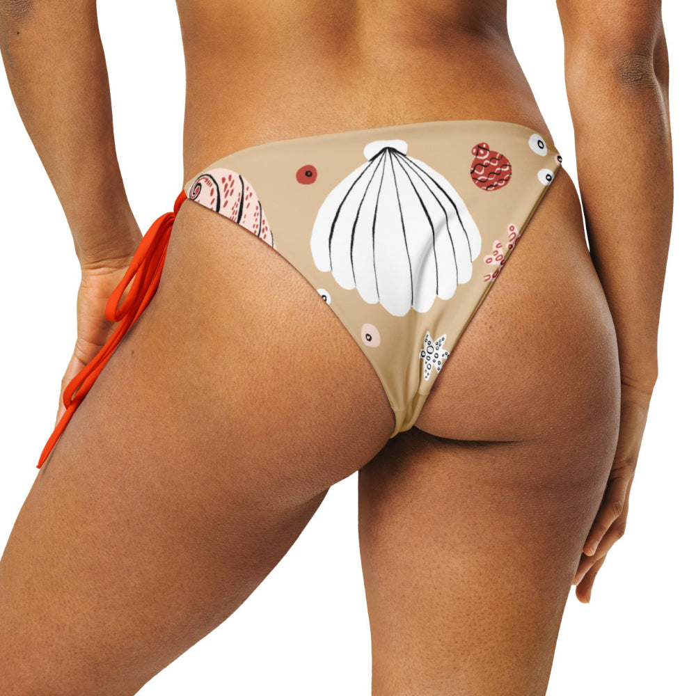 Back view of a woman wearing the Venus’ Secret recycled bikini bottom with illustrated shell details