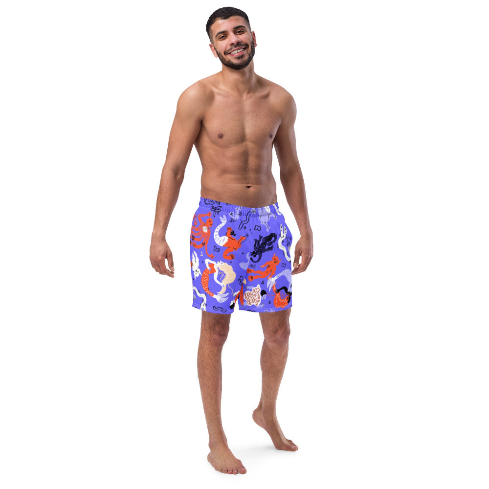 A person wearing vibrant blue Funky Merfolk recycled swimming trunks with merfolk illustrations, front view