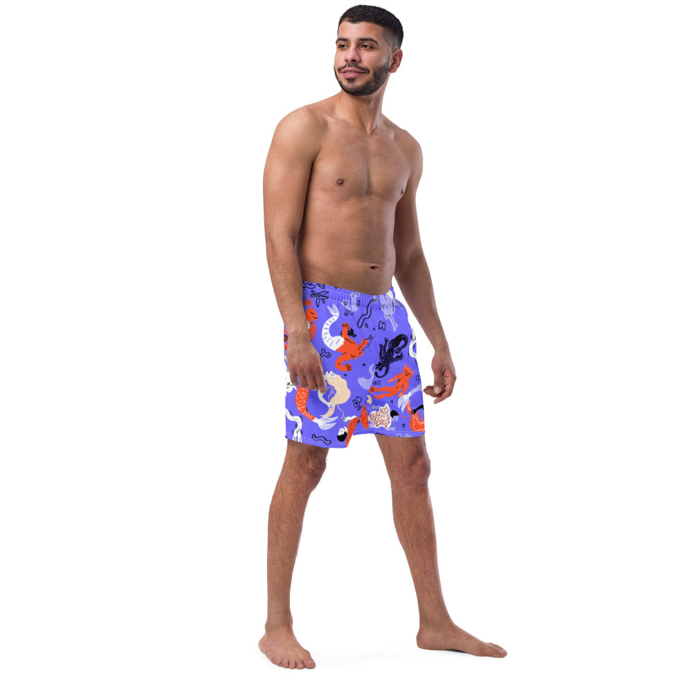 Right front view of a person wearing vibrant blue Funky Merfolk recycled swimming trunks with mermaid illustrations