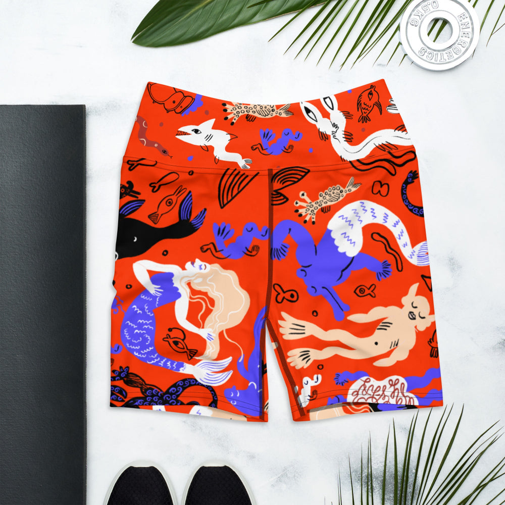 A person wearing Clownfish Red Mermaid Frenzy yoga shorts with a high waistband, front view
