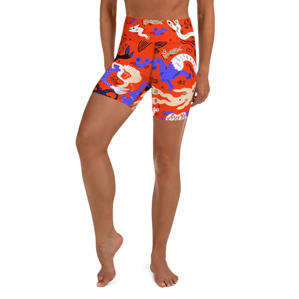 A person wearing Clownfish Red Mermaid Frenzy yoga shorts with a high waistband, front view