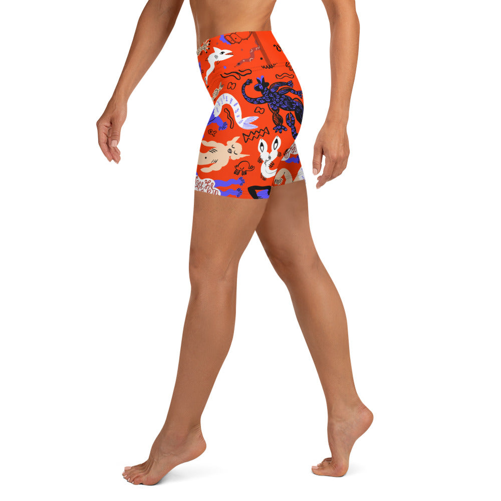 Left side view of a person wearing Clownfish Red Mermaid Frenzy yoga shorts